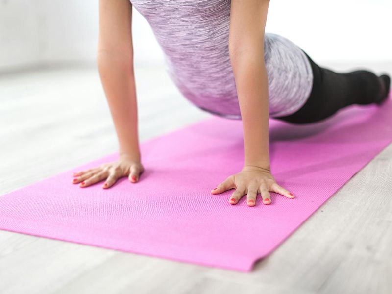 Detailed close-up of a woman doing stretching exercises on a mat.